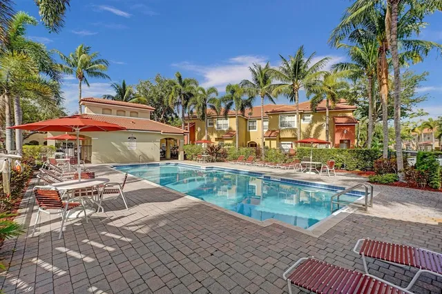 a front view of a house with garden and swimming pool