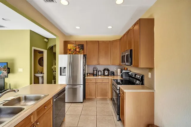 a kitchen with a sink a refrigerator and a stove top oven with wooden floor