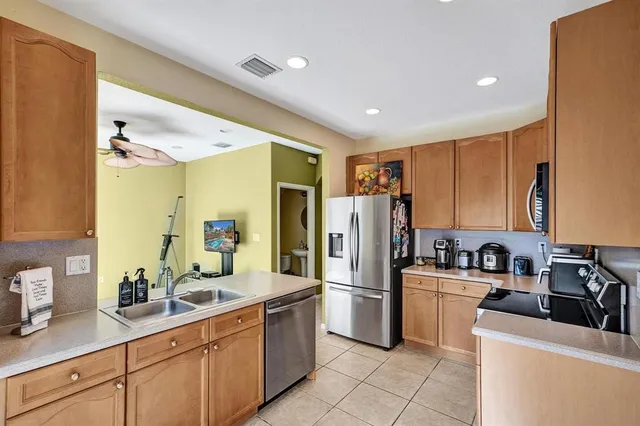 a kitchen with sink a refrigerator and cabinets