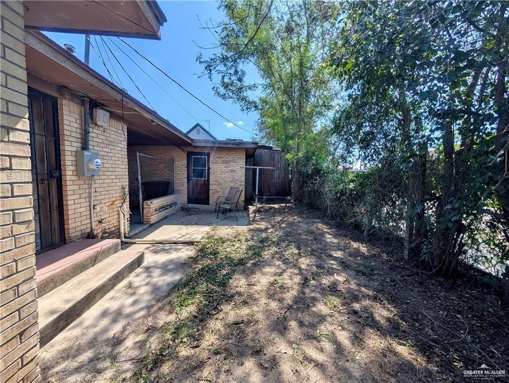 1015 Fresno Avenue McAllen, TX 78501 - Photo 13 of 14 a view of yellow house with a yard and large tree