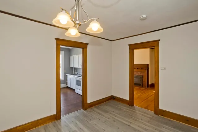a view of a hallway with wooden floor and a bathroom