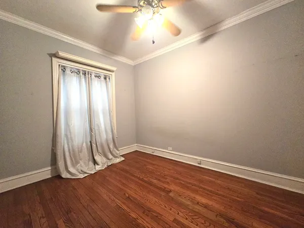 an empty room with wooden floor and a window