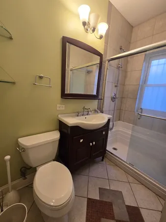 a bathroom with a toilet a sink and mirror