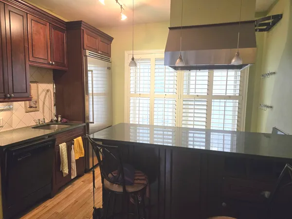 a kitchen with granite countertop a stove a sink and a window