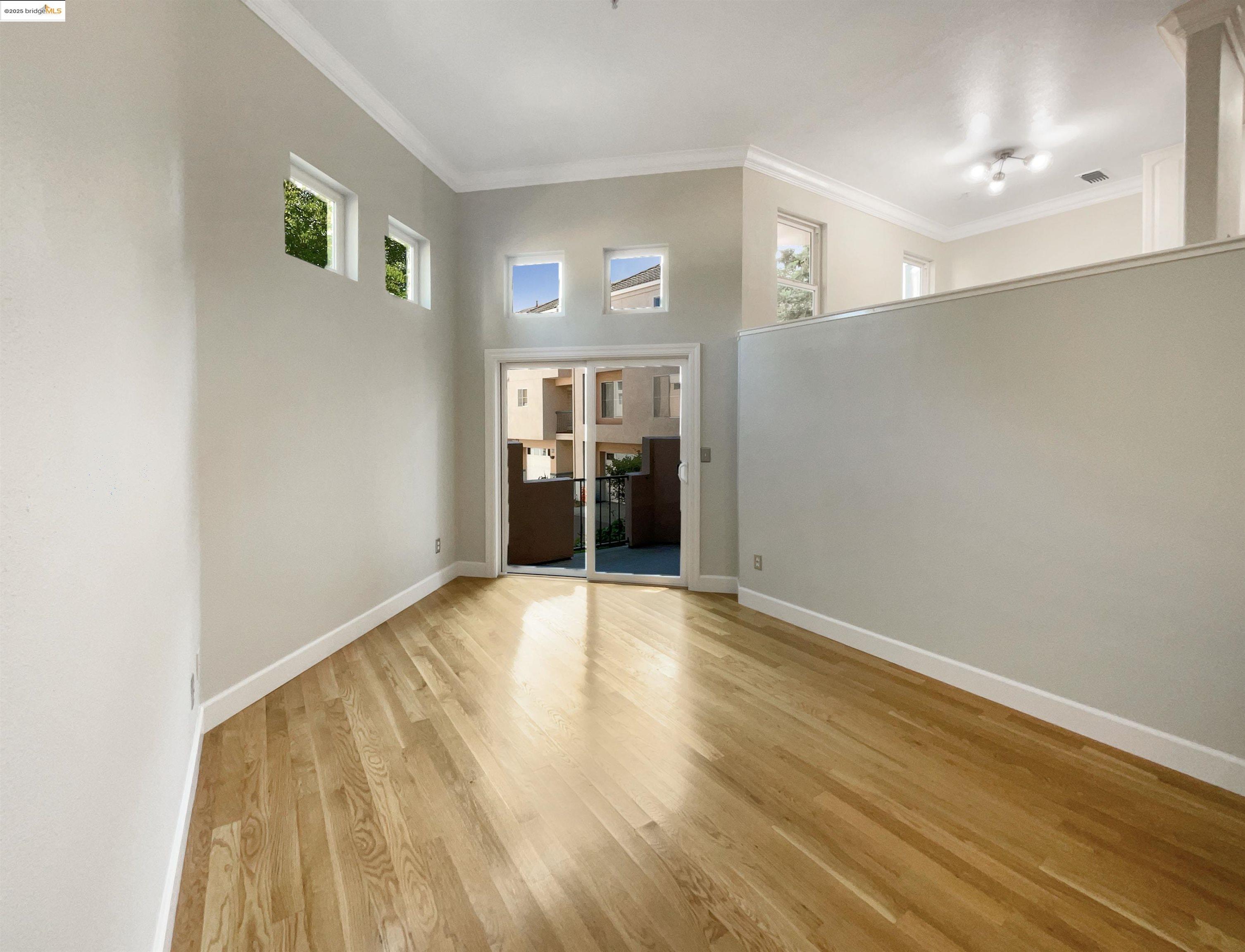 991 Asilomar Terrace, Unit 1 Sunnyvale, CA 94086 - Photo 11 of 20 Empty room featuring wood finished floors, crown molding, and healthy amount of natural light