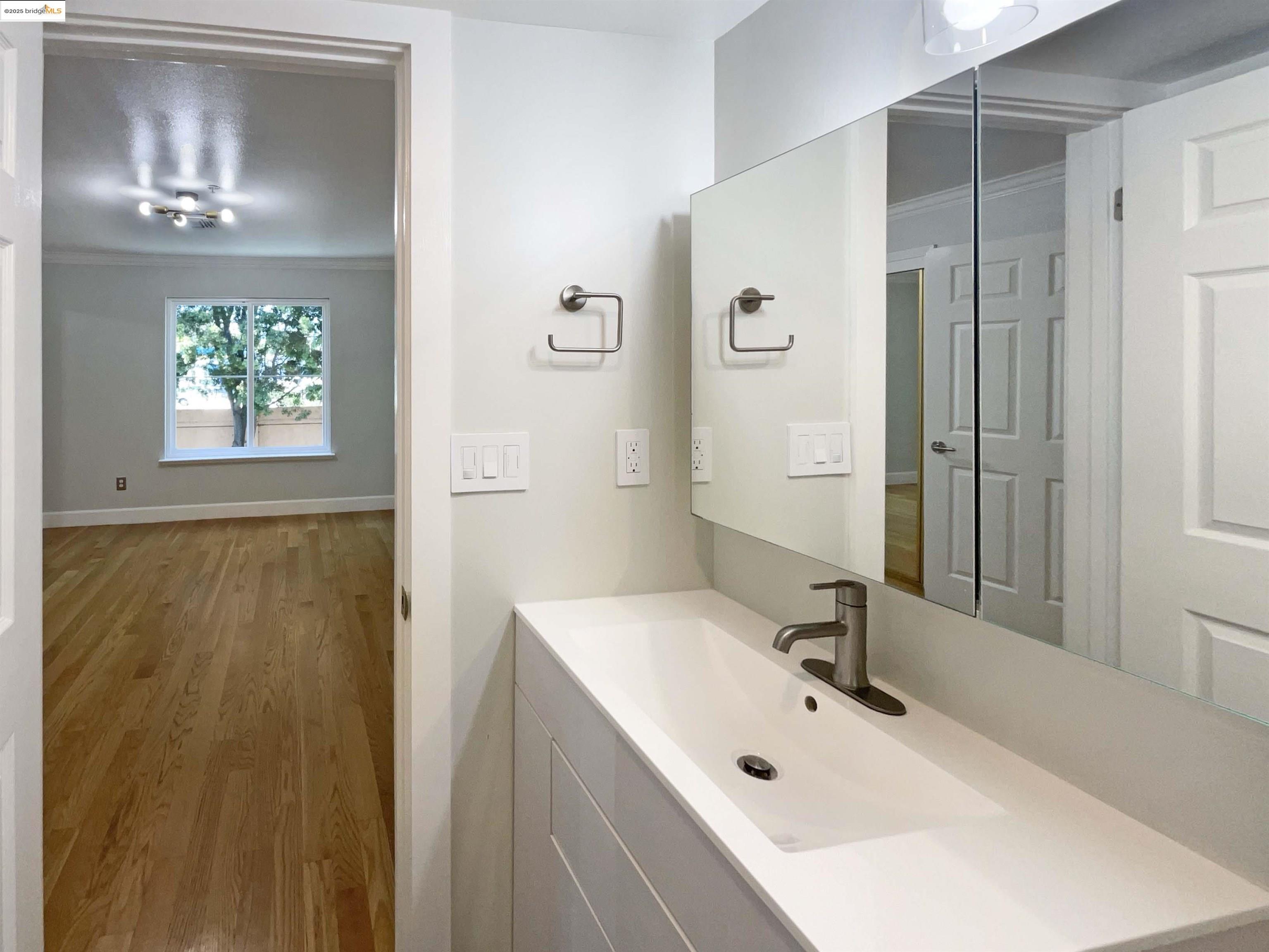 991 Asilomar Terrace, Unit 1 Sunnyvale, CA 94086 - Photo 18 of 20 Bathroom with wood finished floors, ornamental molding, and vanity