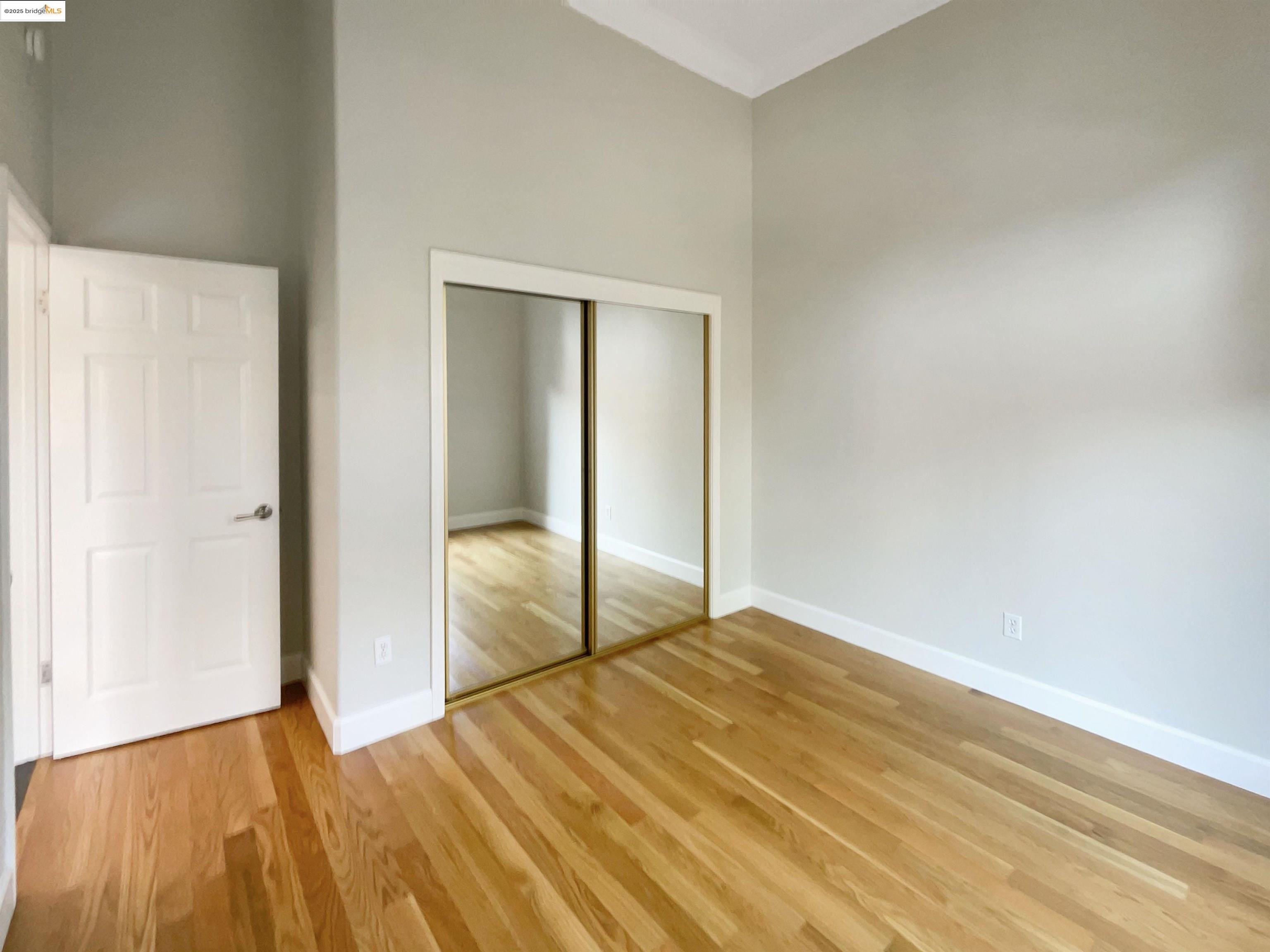 991 Asilomar Terrace, Unit 1 Sunnyvale, CA 94086 - Photo 5 of 20 Unfurnished bedroom featuring high vaulted ceiling, light wood finished floors, and a closet