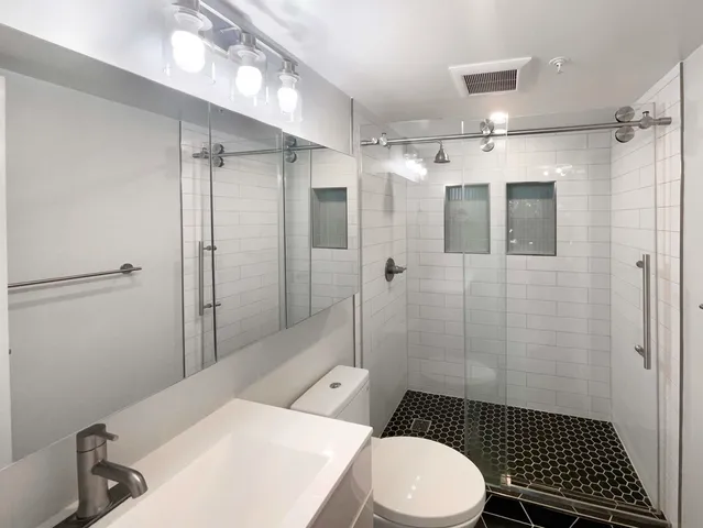a bathroom with a toilet a sink and shower