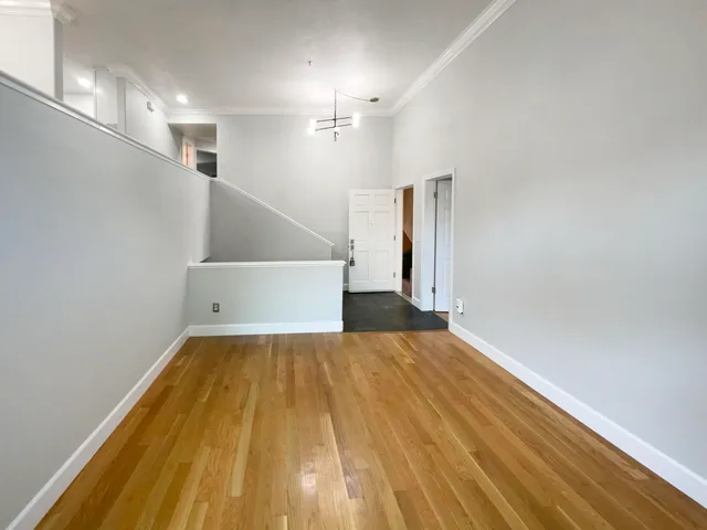 a view of a room with wooden floor and staircase