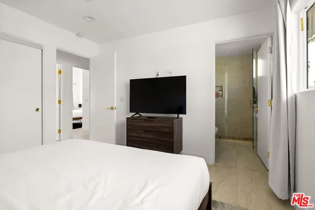 a bedroom with a bed and a large window