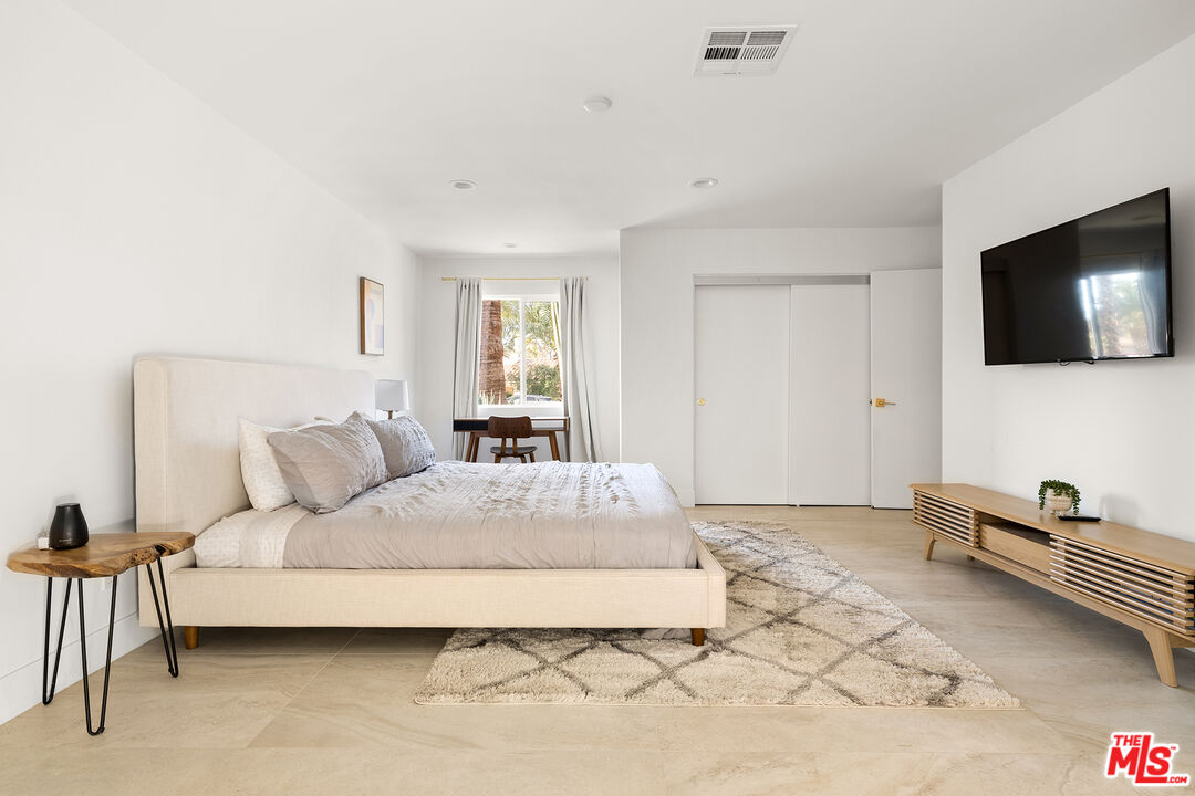 74085 Setting Sun Trail Palm Desert, CA 92260 - Photo 26 of 57 a bedroom with a bed and a flat screen tv