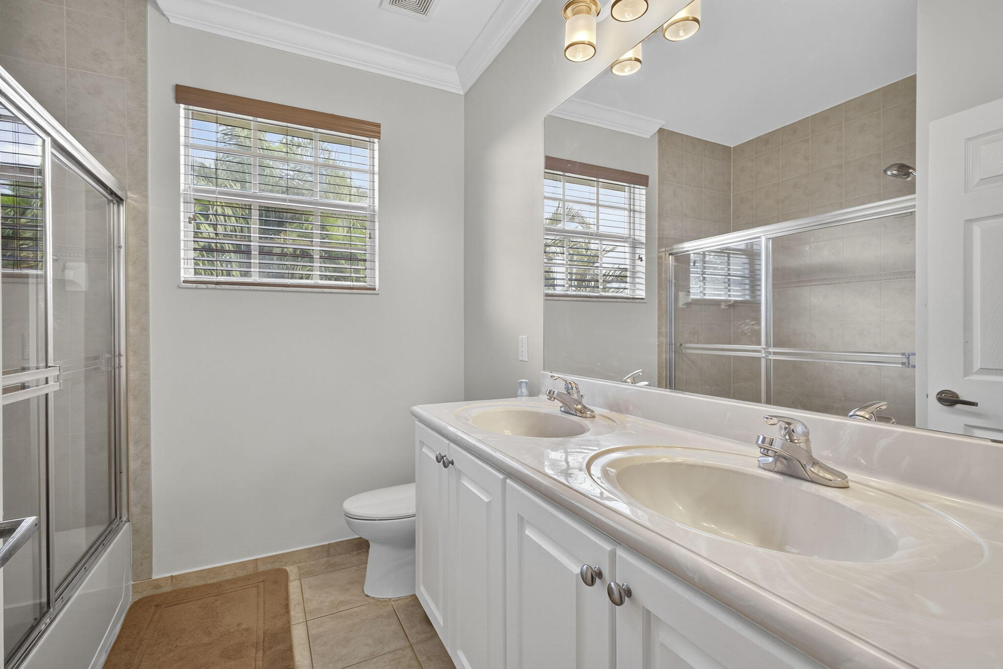 129 Via Bosque Jupiter, FL 33458 - Photo 50 of 92 a bathroom with a granite countertop double vanity sink a mirror and a toilet