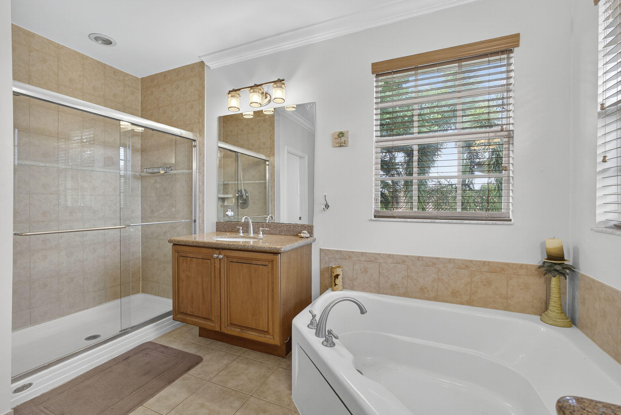 129 Via Bosque Jupiter, FL 33458 - Photo 65 of 92 a bathroom with a granite countertop tub a sink and a large mirror