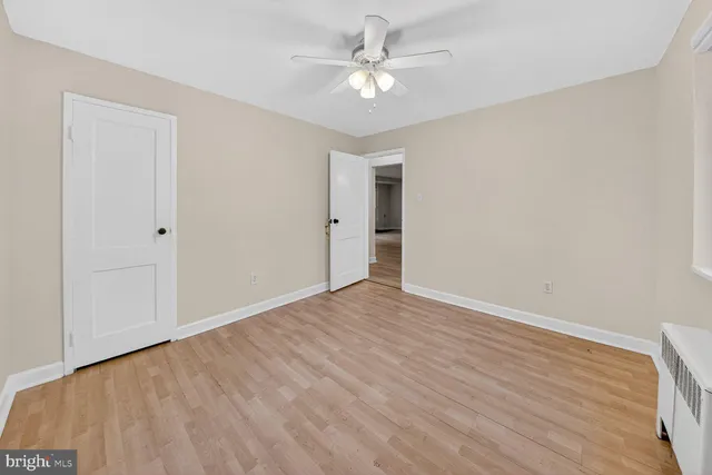 a view of an empty room with window and a ceiling fan