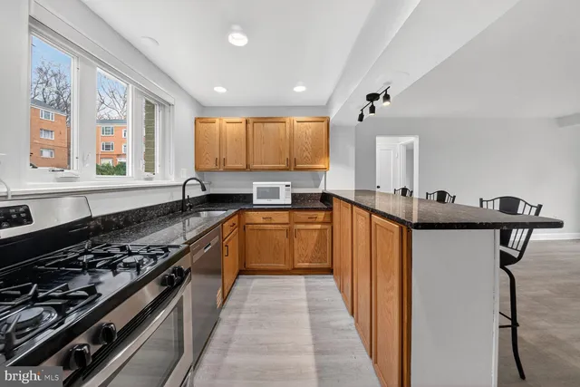 a kitchen with stainless steel appliances a stove a sink and a refrigerator