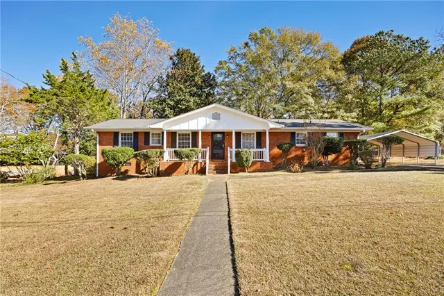 a front view of a house with yard patio and swimming pool