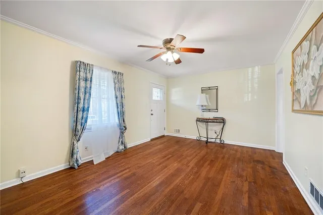 a view of a livingroom with wooden floor and a ceiling fan