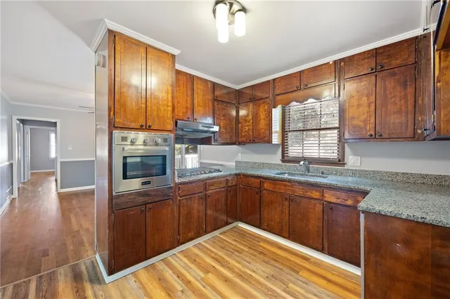 a kitchen with stainless steel appliances granite countertop wooden cabinets a sink and dishwasher