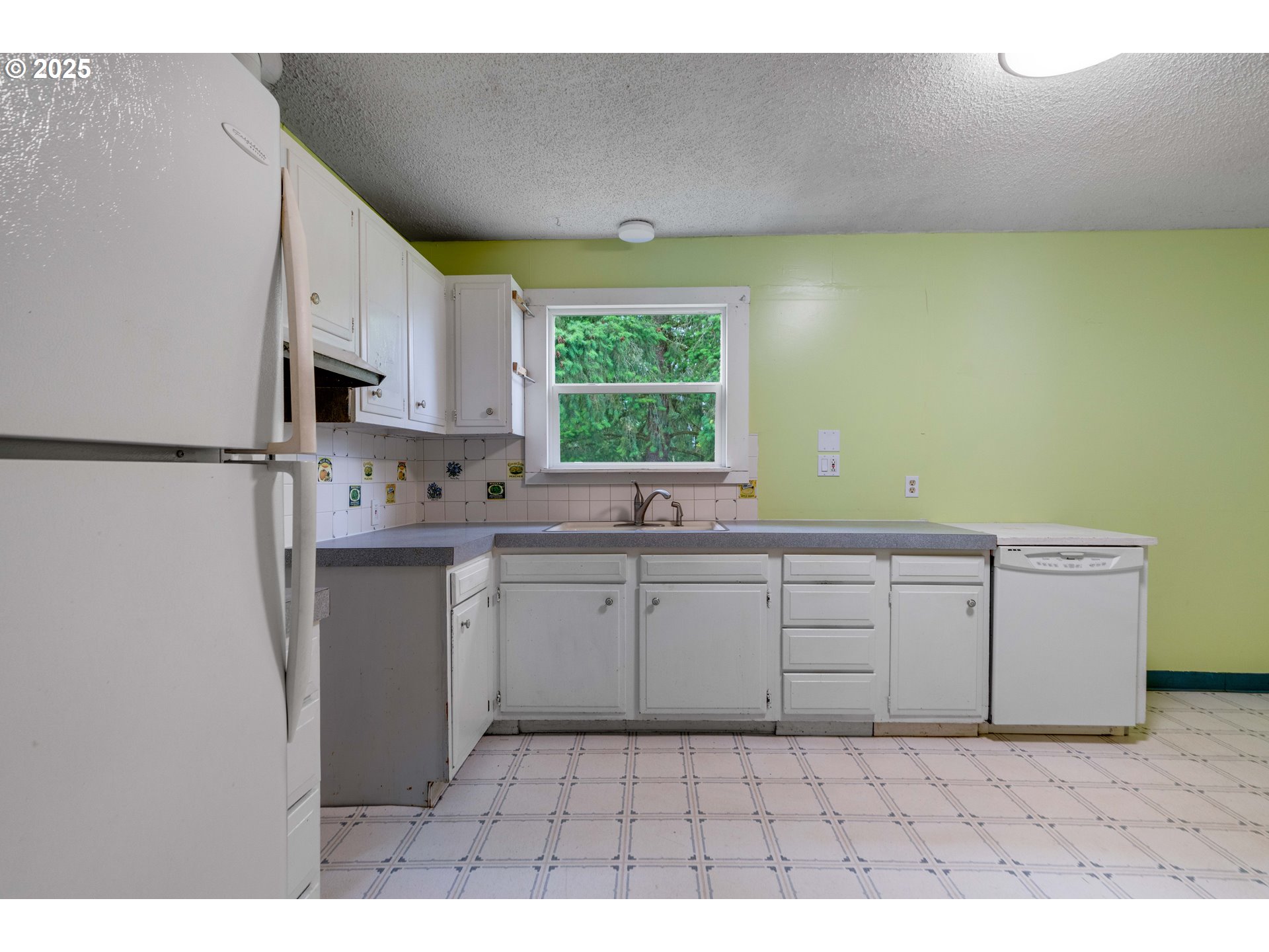 10303 Southeast Bull Run Road Sandy, OR 97055 - Photo 11 of 48 a kitchen with white cabinets a window and a refrigerator