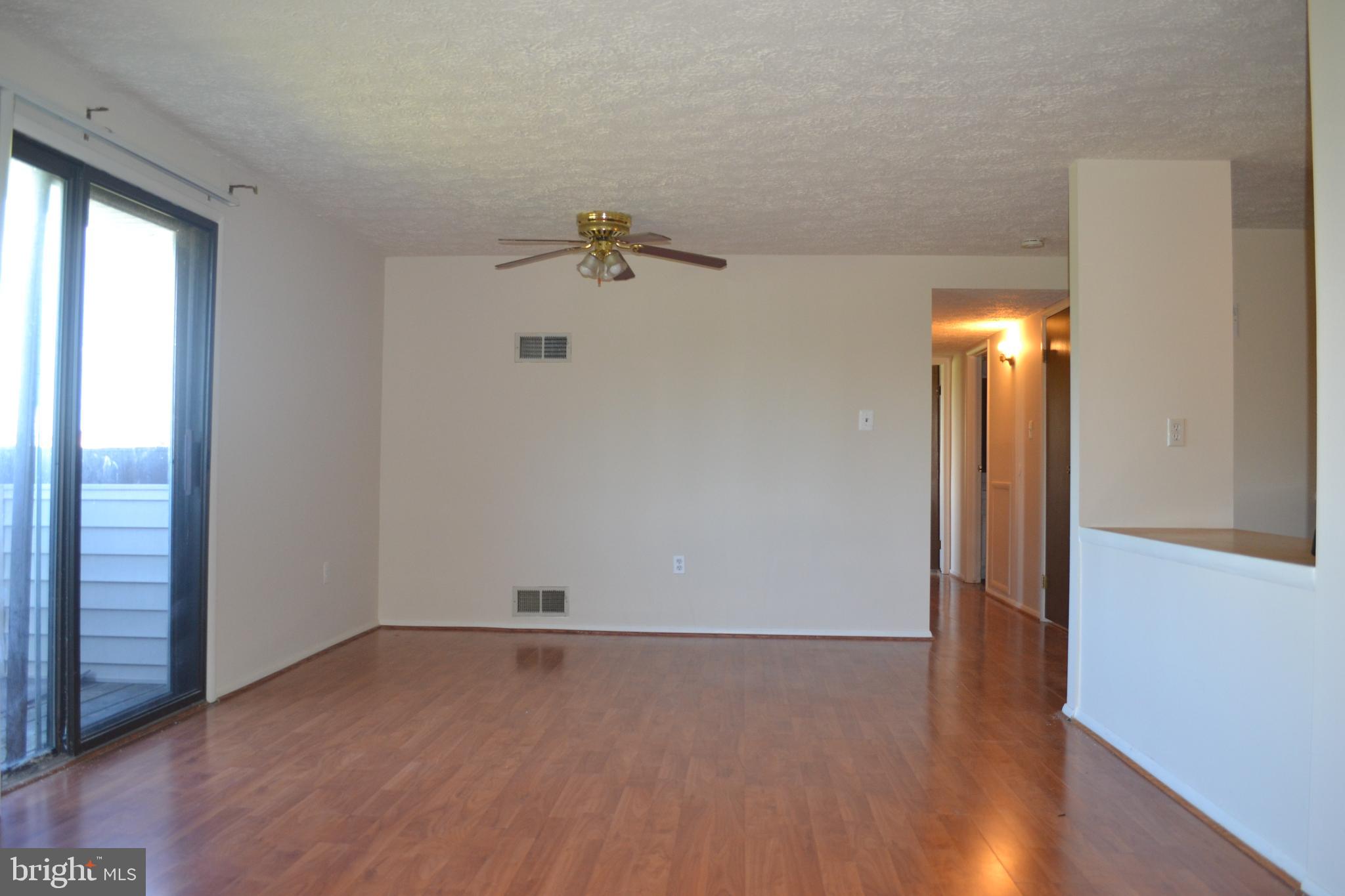 800 L Heather Ridge Drive, Unit 19L Frederick, MD 21702 - Photo 2 of 10 an empty room with wooden floor and windows