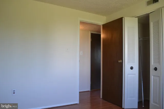 an empty room with wooden floor and closet