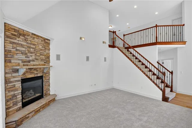 a view of an empty room with wooden floor a fireplace and a window