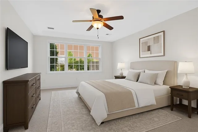 a bedroom with a large bed and a flat tv screen on dresser