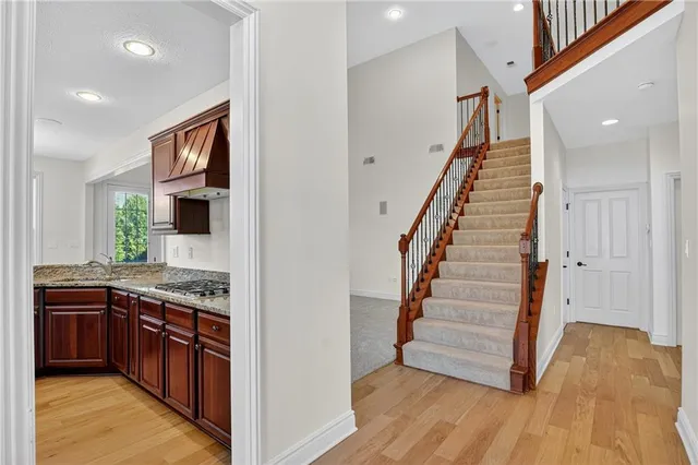 a view of a kitchen cabinets and entryway with wooden floor