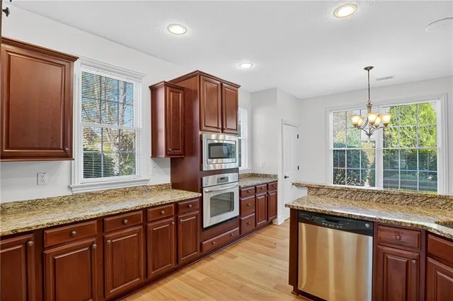 a kitchen with stainless steel appliances granite countertop a stove a sink and a refrigerator