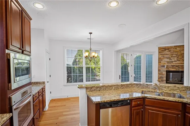 a kitchen with granite countertop kitchen island wooden cabinets and stainless steel appliances