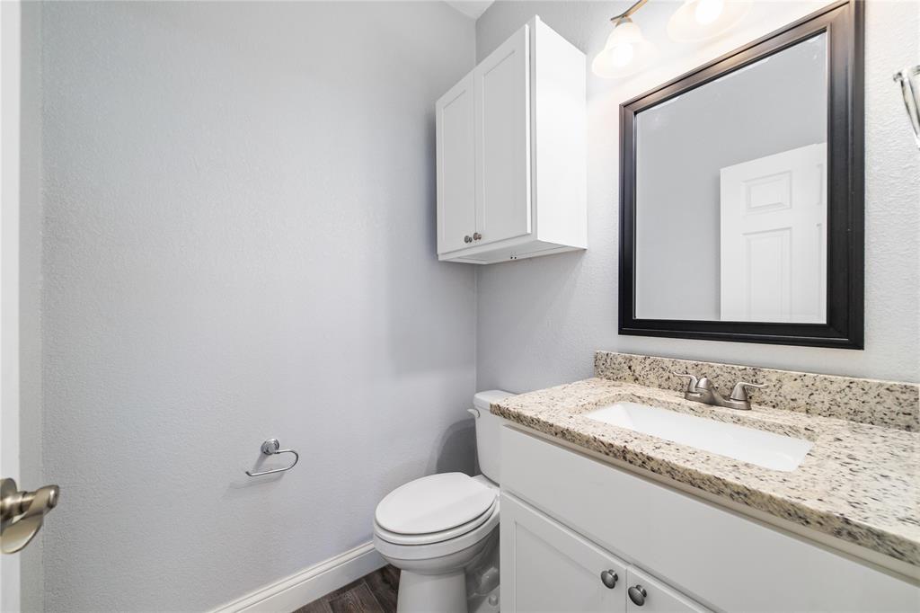 3002 Waterstone Way Brownwood, TX 76801 - Photo 11 of 35 a bathroom with a granite countertop toilet sink and mirror