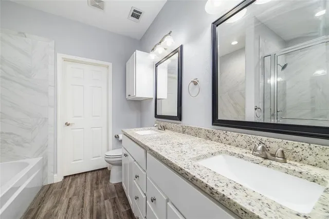 a bathroom with a granite countertop sink and a bathtub
