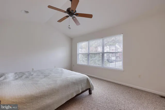 a large bed sitting in a bedroom next to a window
