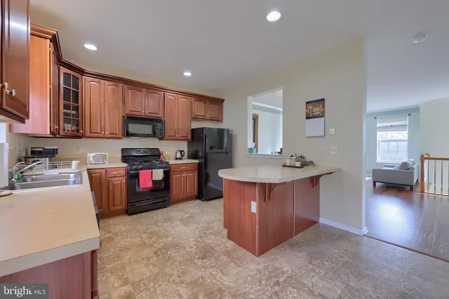 a kitchen with stainless steel appliances granite countertop a sink dishwasher stove and refrigerator
