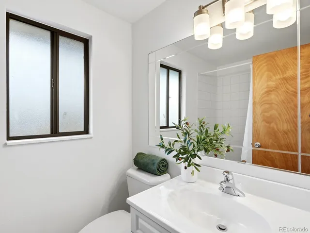 a bathroom with a sink a toilet and mirror