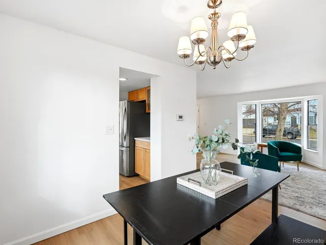 a view of a dining room with furniture a chandelier and wooden floor