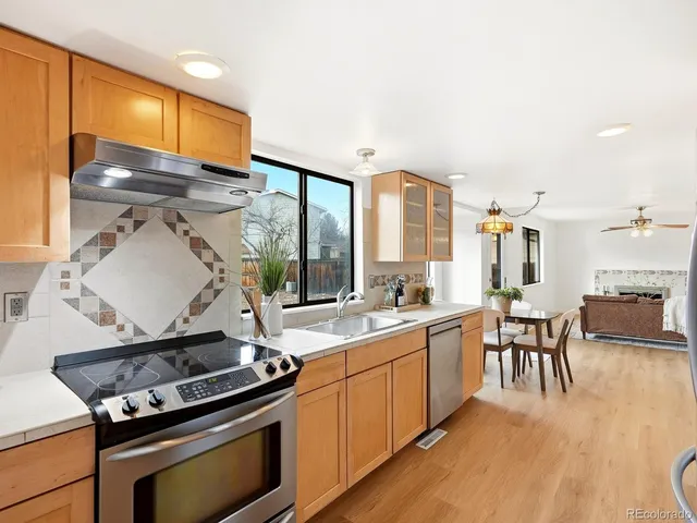 a kitchen with a stove and wooden floor