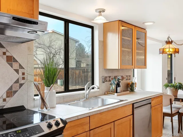 a kitchen with stainless steel appliances granite countertop a sink a oven and a large window