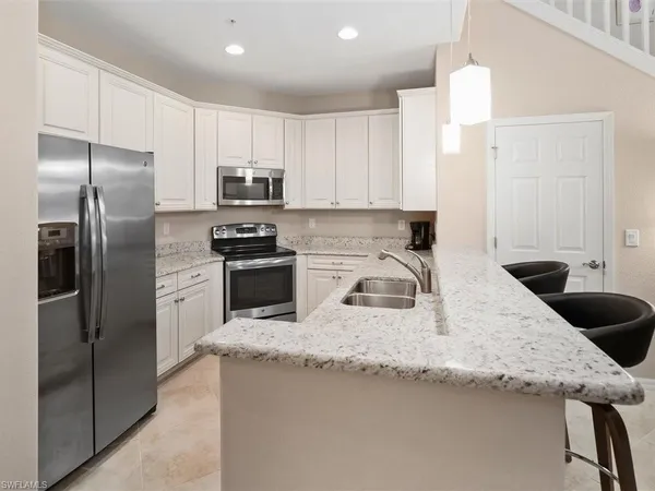 a kitchen with stainless steel appliances granite countertop a sink stove and cabinets