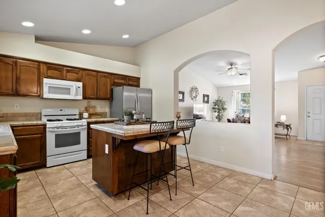 a kitchen with a sink a counter top space appliances and cabinets