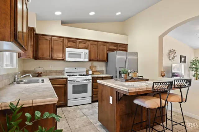 a kitchen with a stove a sink a dining table and chairs
