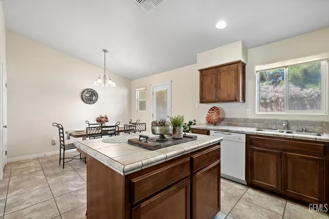 a kitchen with a sink a stove and chairs