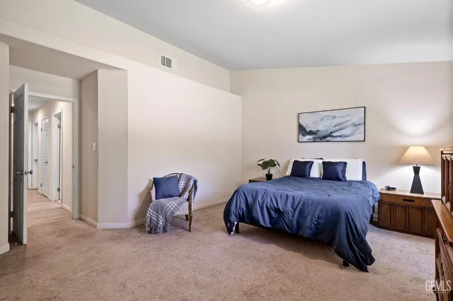 a living room with a bed furniture and painting on the wall