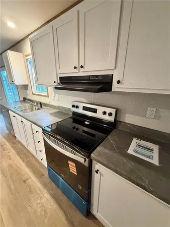 a kitchen with stainless steel appliances granite countertop a sink and a stove