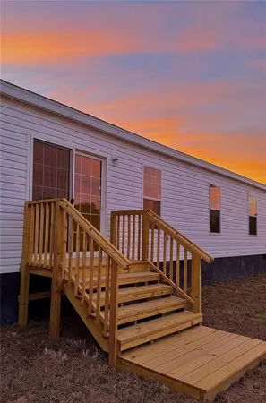 a view of a house with wooden deck and furniture