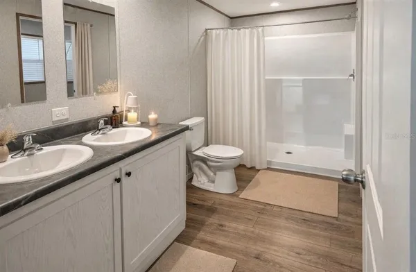 a bathroom with a granite countertop sink toilet and shower