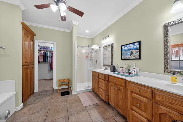 a spacious bathroom with a double vanity sink a mirror and a shower