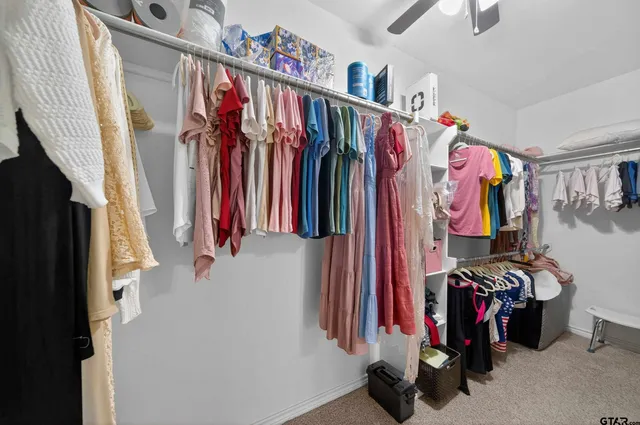 a view of walk in closet with clothes