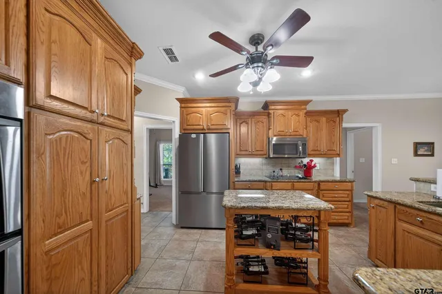 a kitchen with stainless steel appliances granite countertop a refrigerator and a sink