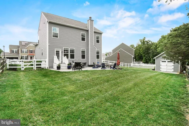 a view of a house with a big yard and sitting area